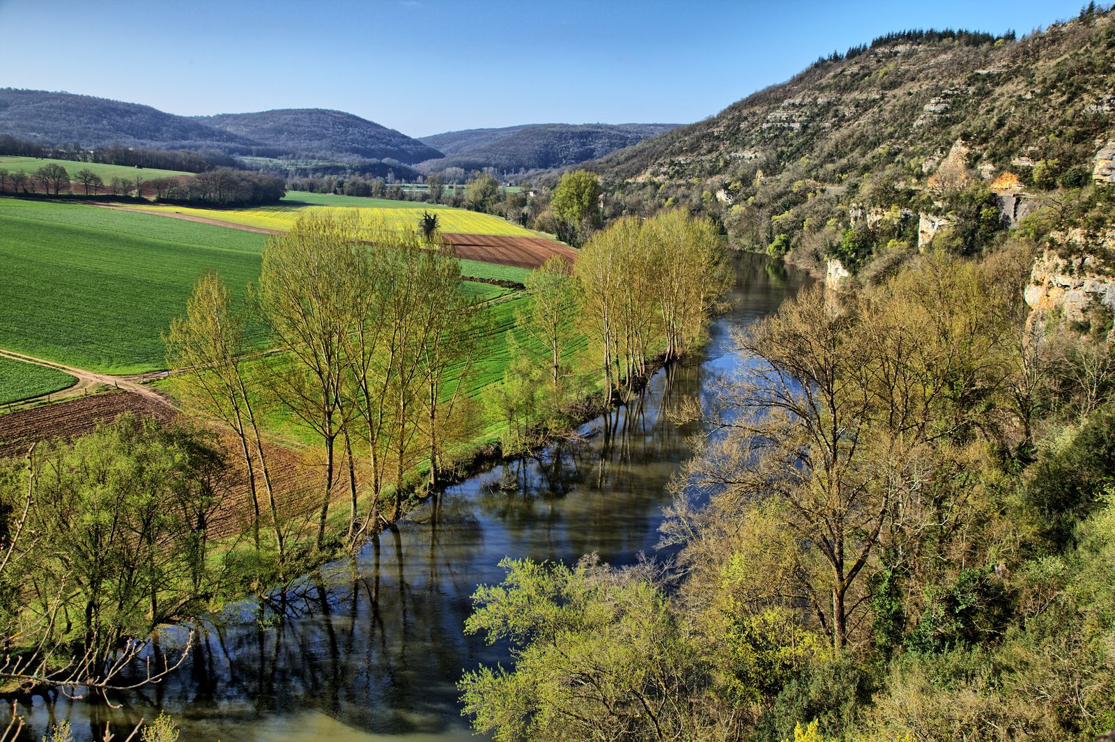 La vallée du Lot vue d’en haut près de Saint-Cirq-Lapopie : la rivière, les champs cultivés et les falaises calcaires du causse